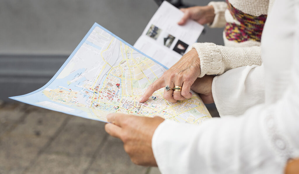 Mid section of two senior women holding map